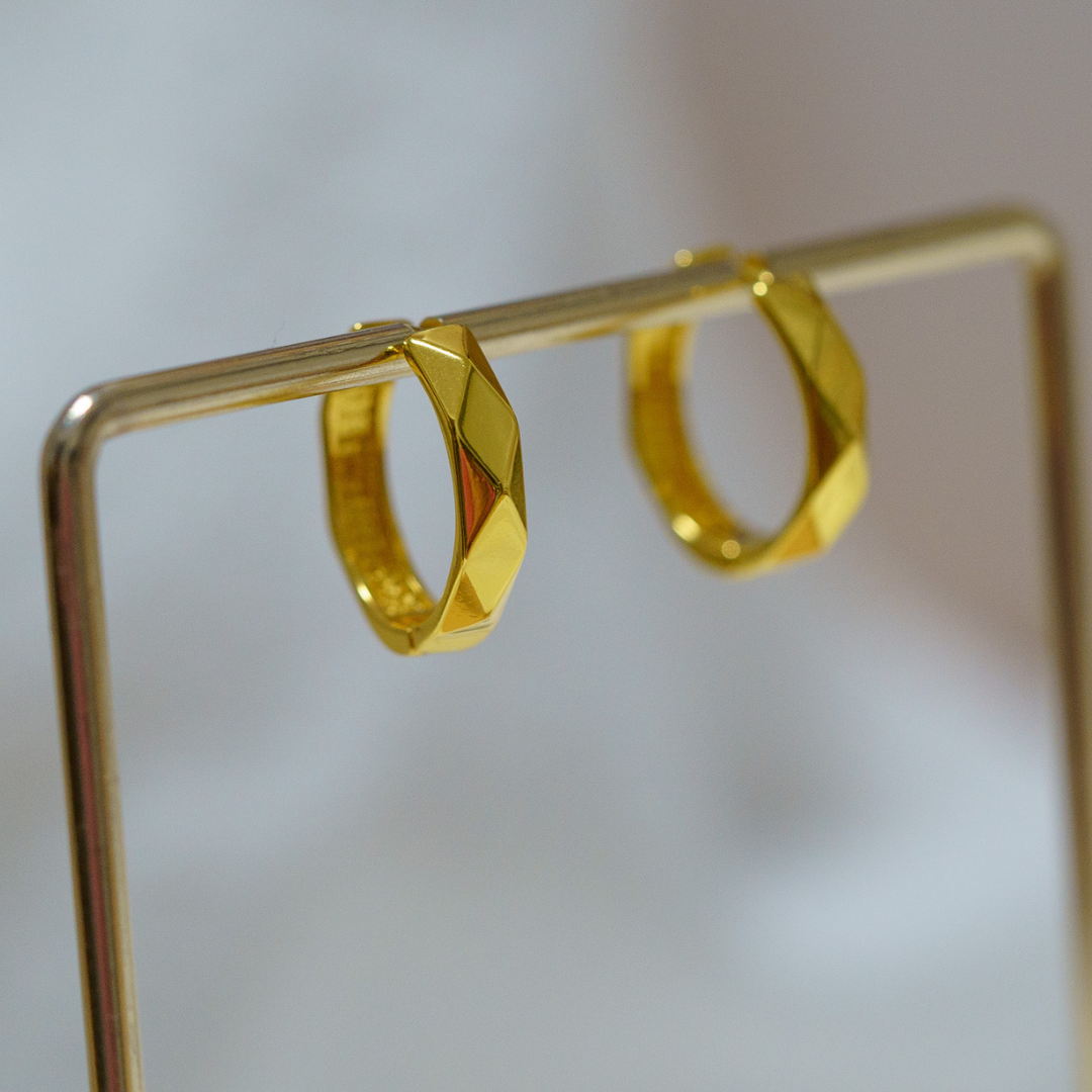 金色菱面切角耳圈掛在金屬架上的實拍
