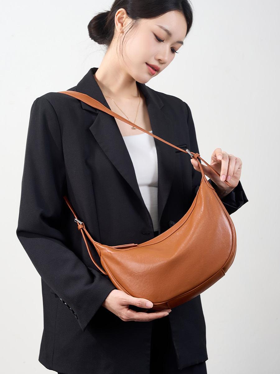 Model carrying Luna Leather Hobo Bag in Caramel – on shoulder