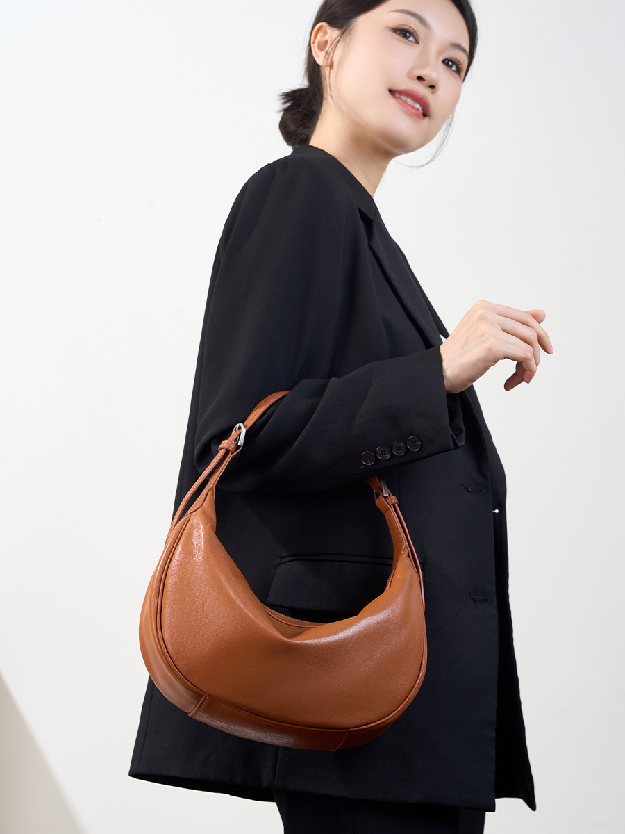 Model carrying Luna Leather Hobo Bag in Caramel – arm carry style