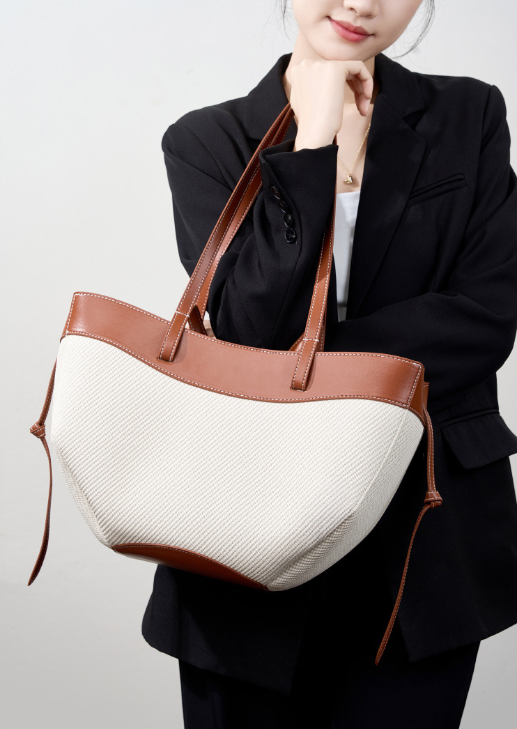Model showcasing Wing Curve Leather Tote Bag in Brown