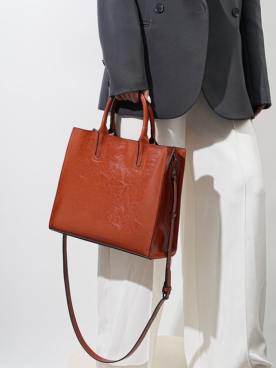 Model showcasing Premium Leather Top Handle Tote Bag in Caramel
