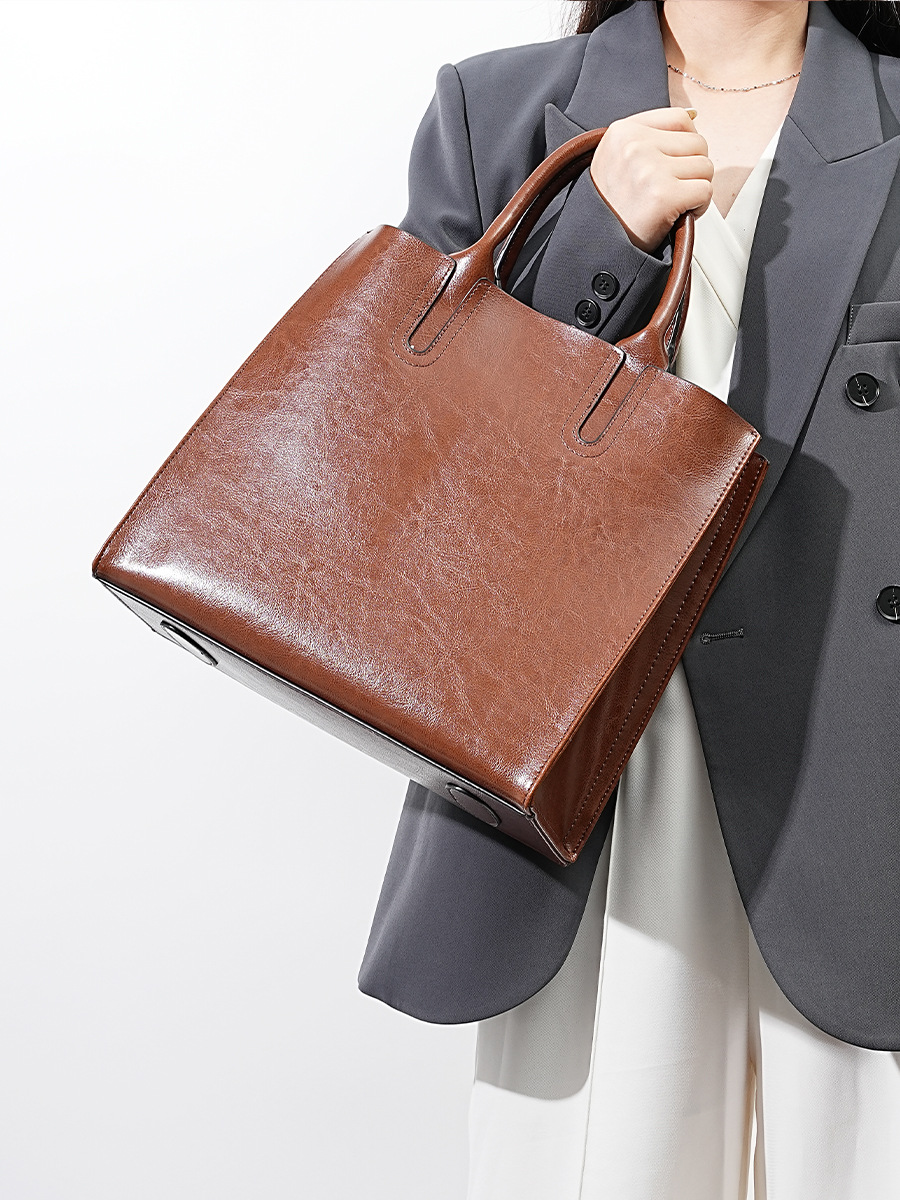 Model showcasing Premium Leather Top Handle Tote Bag in Coffee