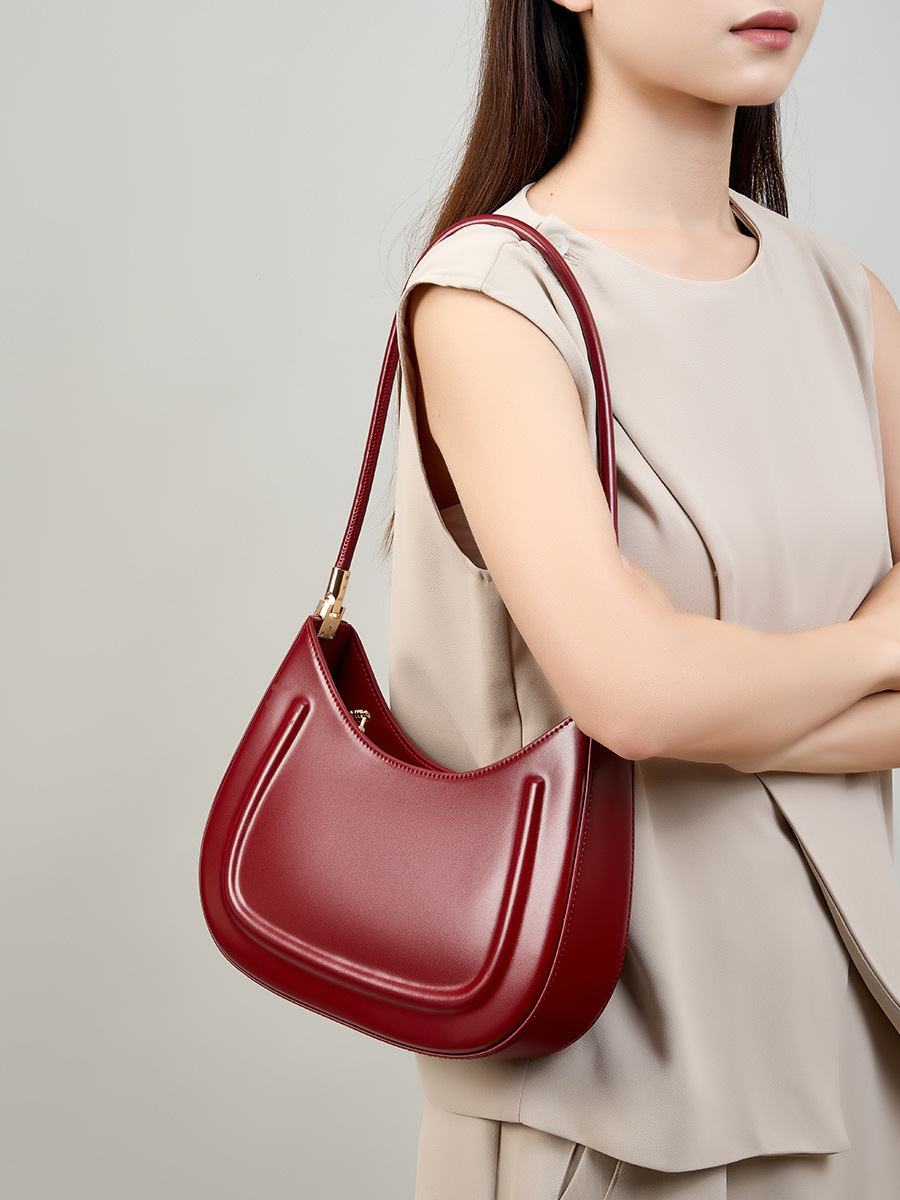 Model carrying Oil Waxed Leather Minimalist Half Moon Bag in Burgundy – on shoulder