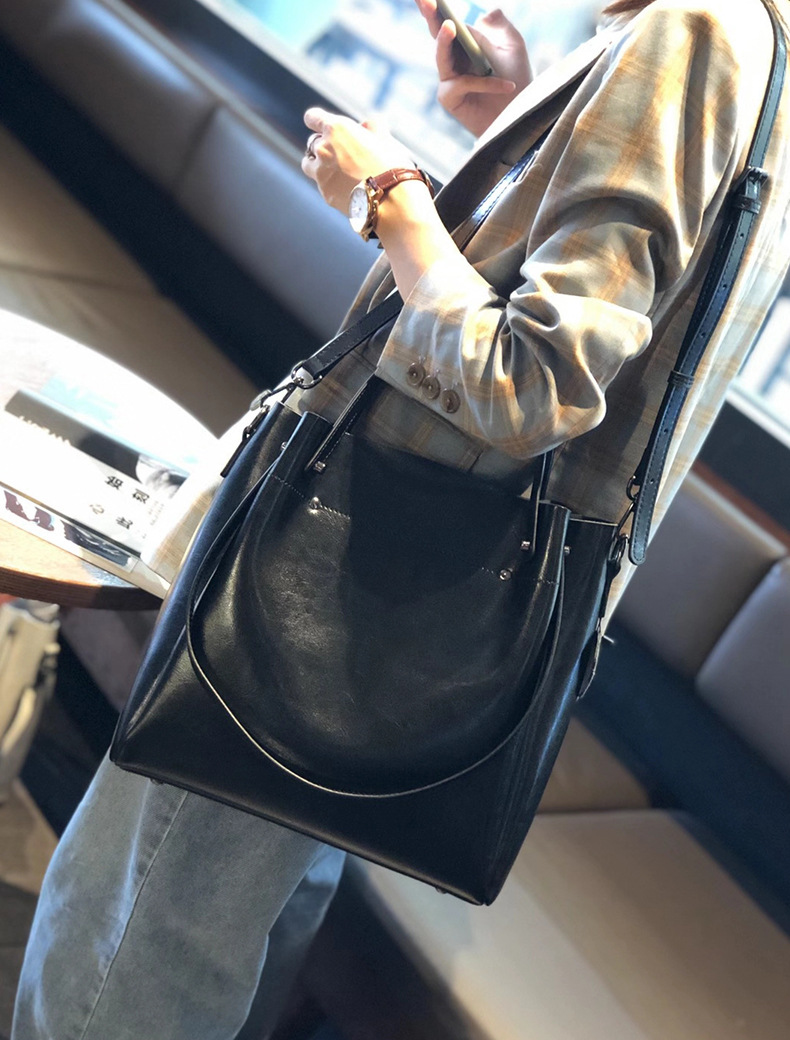 Model carrying Elegant Oil Waxed Leather Top Handle Tote Bag in Black