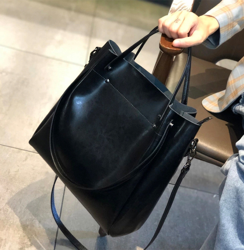 Model carrying Elegant Oil Waxed Leather Top Handle Tote Bag in Black