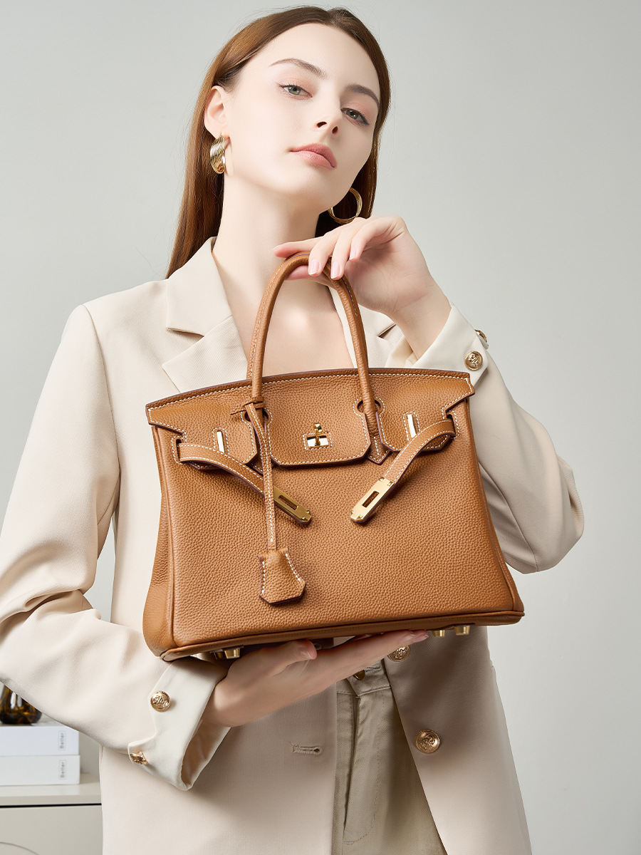 Model showcasing Premium Togo Leather Structured Top Handle Bag in Golden Brown