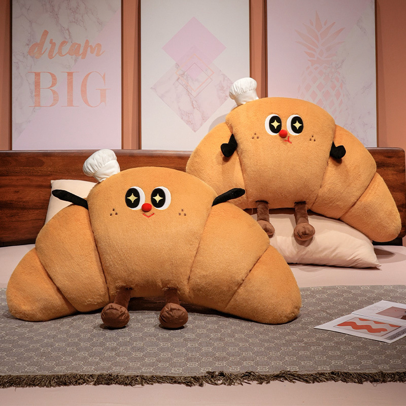 Croissant plush pillows arranged on a bed as cozy backrest cushions, soft croissant-shaped pillows for bedroom relaxation