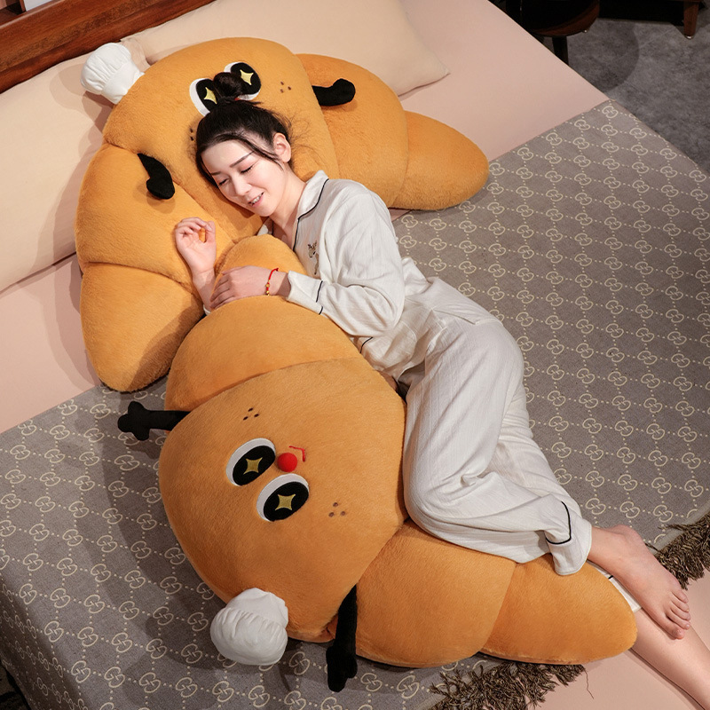 Croissant plush pillow used as a hugging and side sleeping cushion, soft croissant-shaped pillow for cozy bed lounging and relaxation