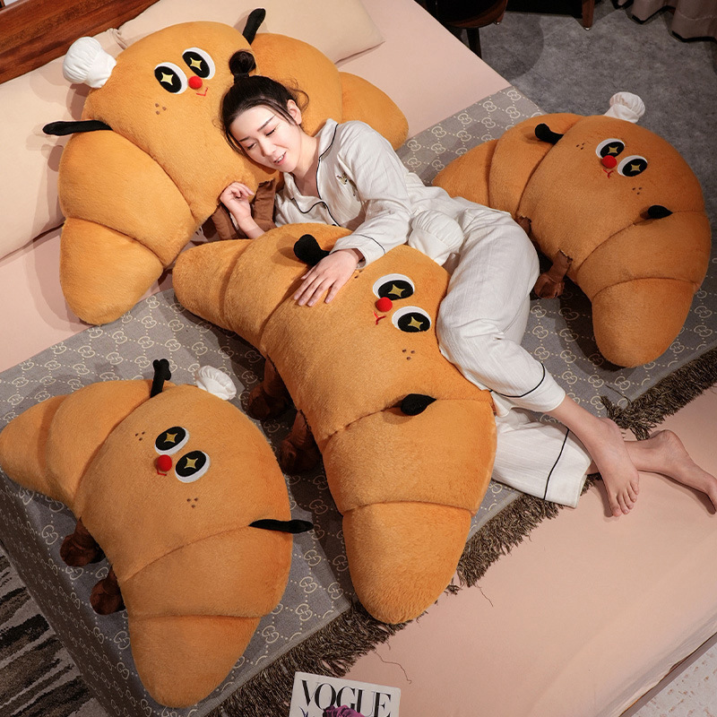 Croissant plush pillow used as a hugging and lounging cushion, soft croissant-shaped pillow for cozy bed relaxation