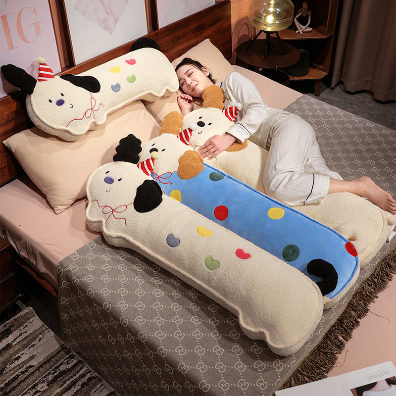 Perky ears puppy long plush pillows in polka dot, candy heart and happy designs displayed on bed, soft dog body pillows for hugging and cozy bedroom decor