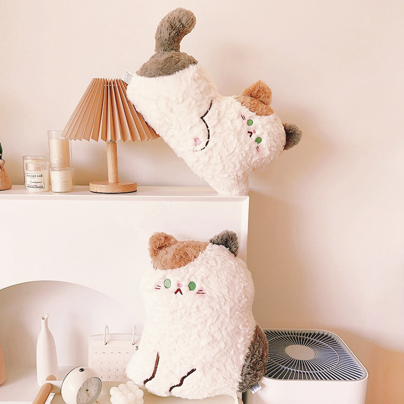 Cute calico cat plush pillow in sitting and lying styles displayed on a shelf, featuring soft fluffy plush fabric and cozy home decor styling