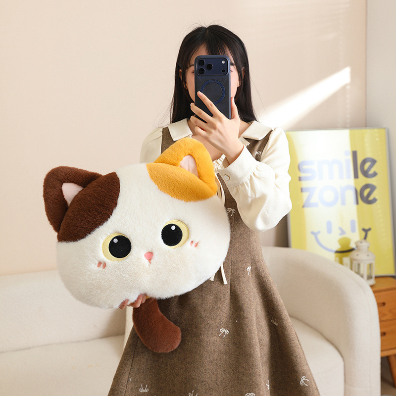 Calico cat head plush pillow with big eyes and soft plush fabric, a cute fluffy cushion ideal for hugging, resting, and adding warmth to cozy home spaces