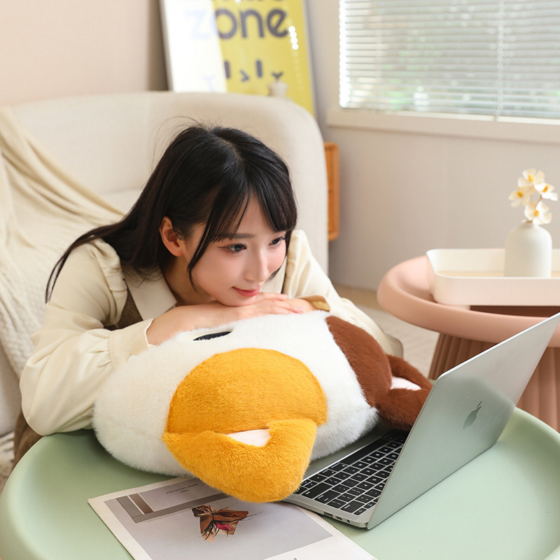 Calico cat head plush pillow used as a soft cushion on a cozy sofa, fluffy cat face pillow perfect for hugging, relaxing, or resting while using a laptop