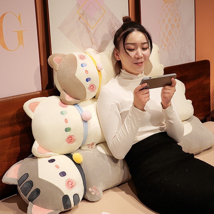 Cuddle cat long plush pillow stacked on bed as soft cat body pillows, plush cushions for back support, relaxing, and cozy bedroom comfort