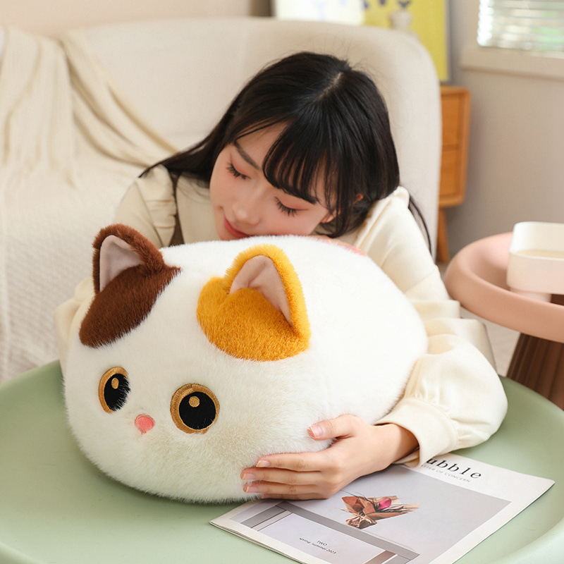 Bread cat plush pillow in calico style resting on a table, soft round loaf-cat cushion with fluffy texture for hugging, relaxing and cozy home decor