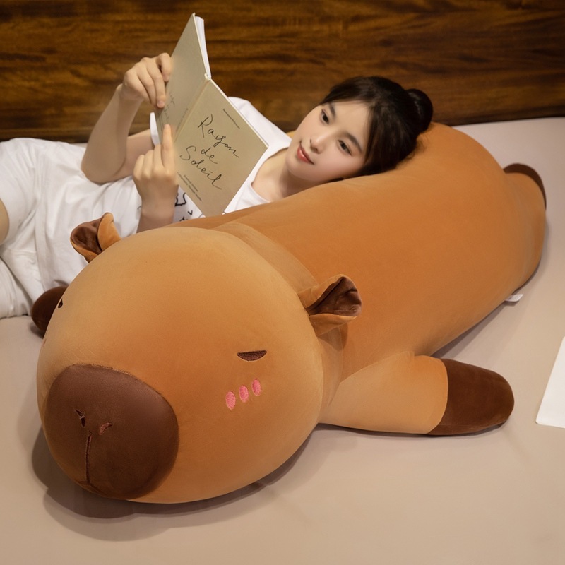 Capybara plush pillow as a long hugging body pillow, perfect for lying down, reading, and enjoying a cozy and relaxed moment