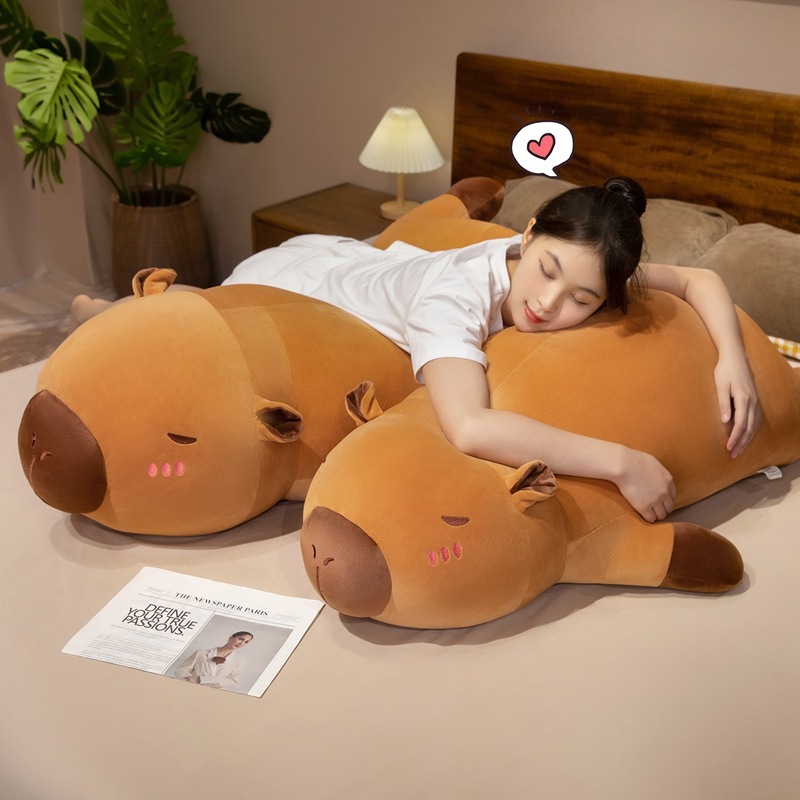 Capybara plush pillow used for hugging and relaxing on the bed, offering soft comfort and a cozy sleeping experience