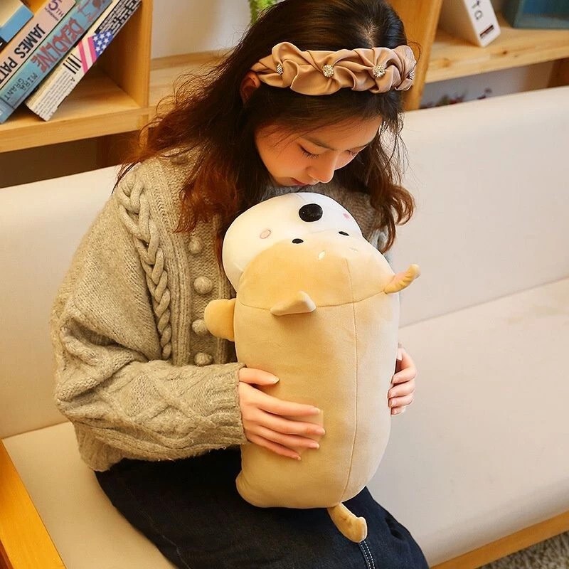 Khaki lying dog plush pillow hugged on a sofa, plush and supportive cushion ideal for relaxing, napping, and creating a warm and cozy atmosphere