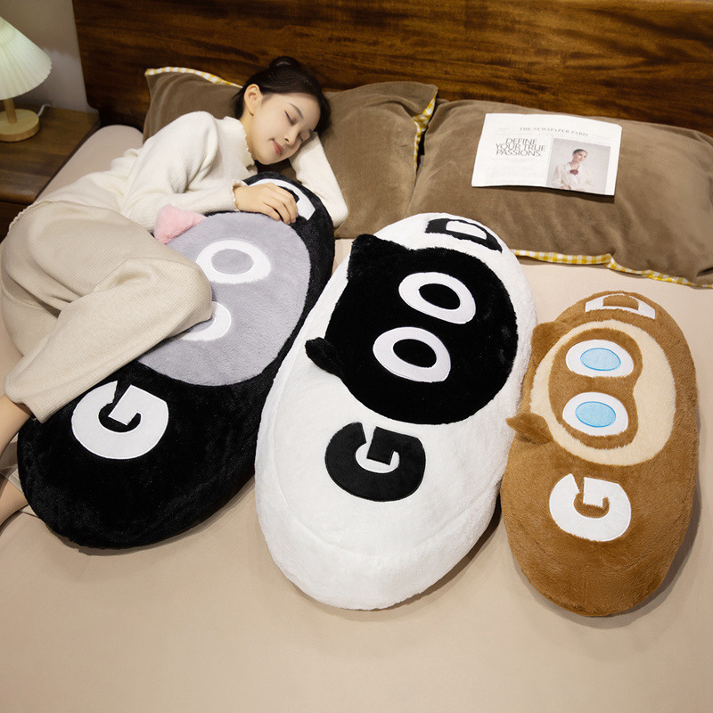 GOOD cat long plush pillow used as a full body cushion for relaxing, hugging, and comfortable lounging on bed in a cozy home setting
