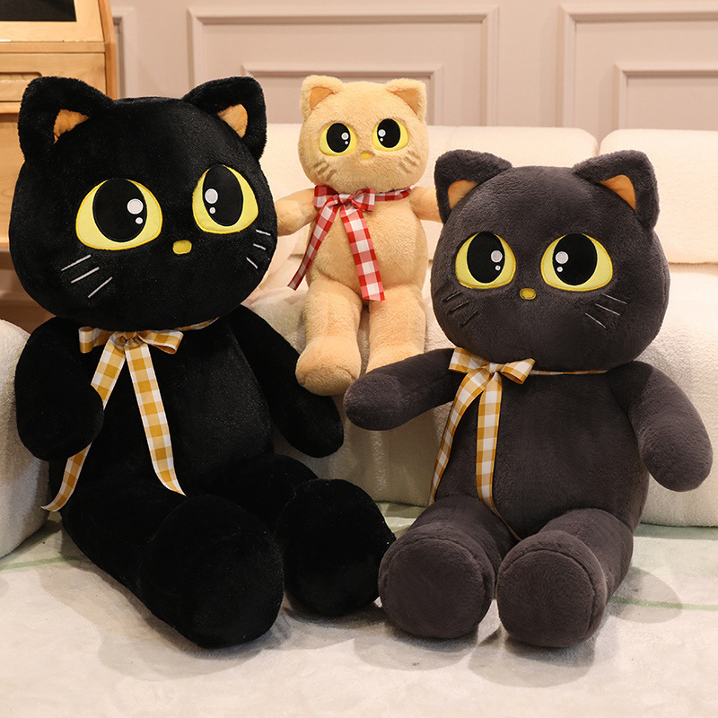 Cat plush toys in black, gray, and light brown with ribbon detail, soft stuffed animals arranged for cozy home decor display