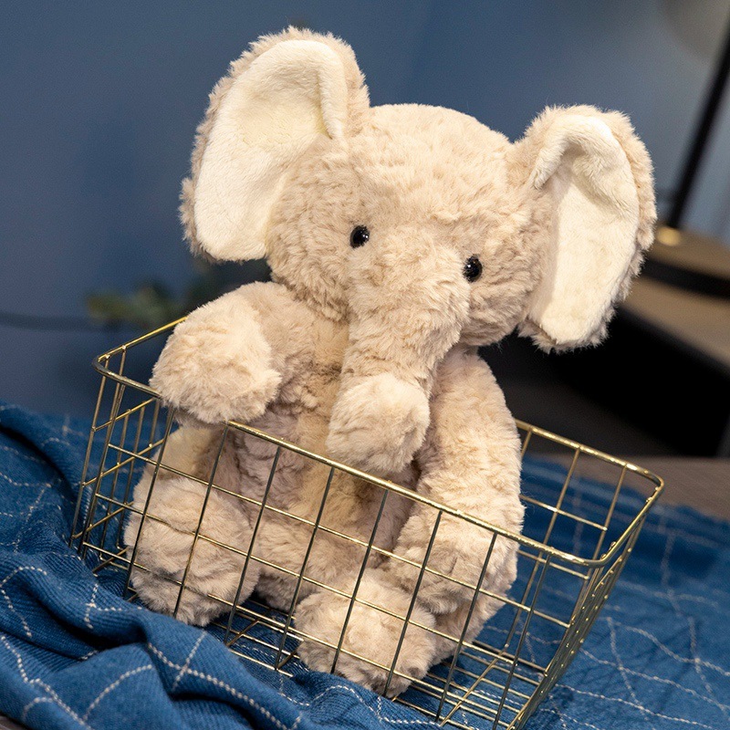 Elephant plush toy in a sitting pose displayed in a basket, ideal as a cute decorative accent for cozy home spaces
