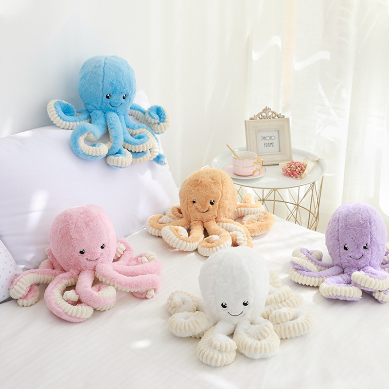 Soft octopus plush toy with long tentacles in pastel colors, placed on a bed as a cute and cozy decorative stuffed animal