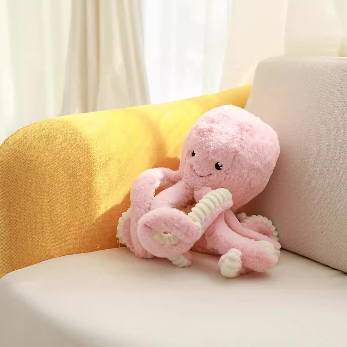 Pink octopus plush toy resting on a sofa in warm sunlight, showing soft texture and relaxing cozy mood