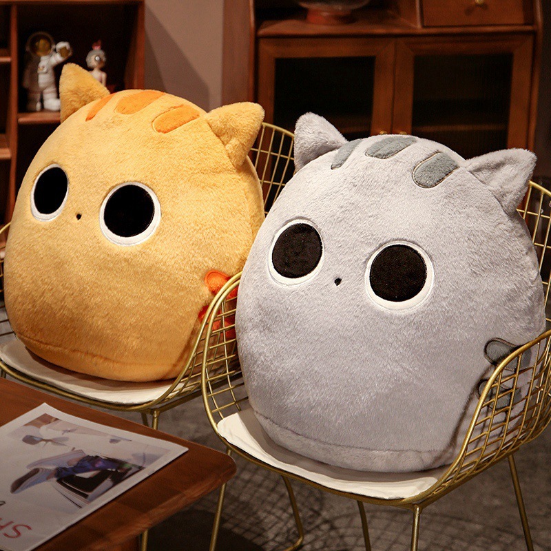 Orange and gray round cat plush pillows on chairs, soft chubby cushions for cozy home decor and lounging