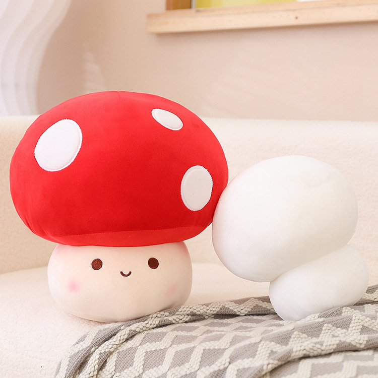 Red mushroom plush toy with white spots paired with a white mushroom plush, placed on a sofa with a soft blanket, creating a cozy and cute home decor setting
