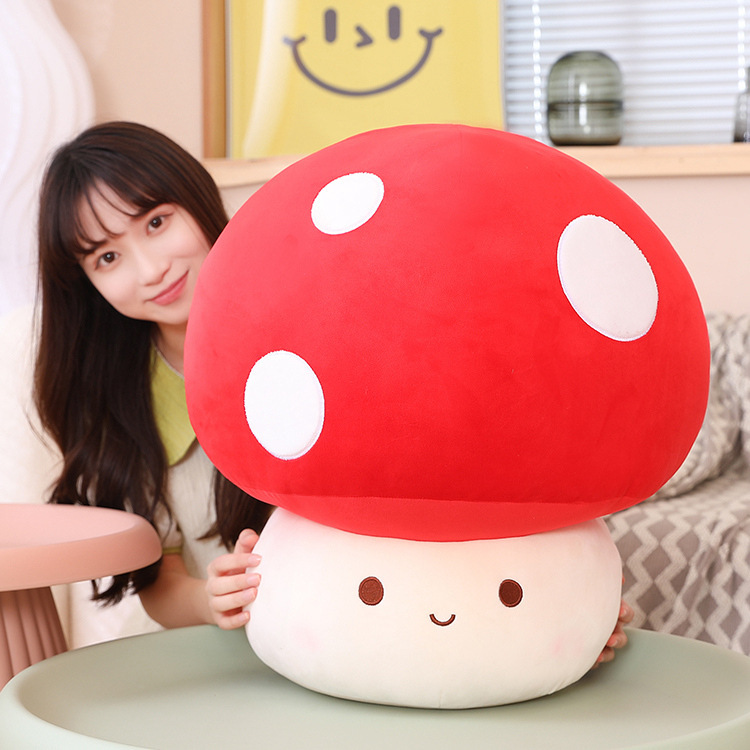 Large red mushroom plush toy with a soft, smooth surface and cute smiling face, placed in a cozy indoor setting, perfect for decorating spaces and adding a warm, playful touch