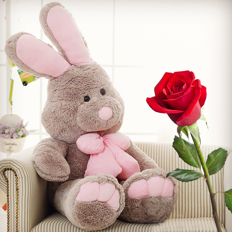 Rabbit plush toy with long ears and pink bow placed on a sofa, creating a warm and cozy atmosphere, ideal as a comforting gift or decorative piece