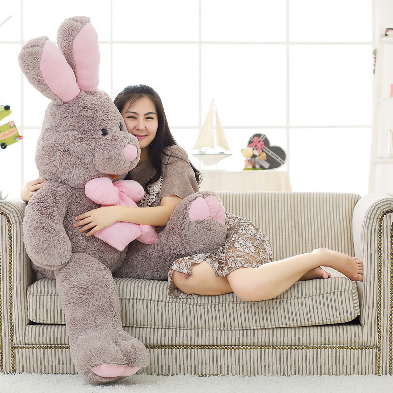 Rabbit plush toy with long ears and pink bow, featuring soft plush fabric and fluffy filling for comfortable hugging and cozy lounging