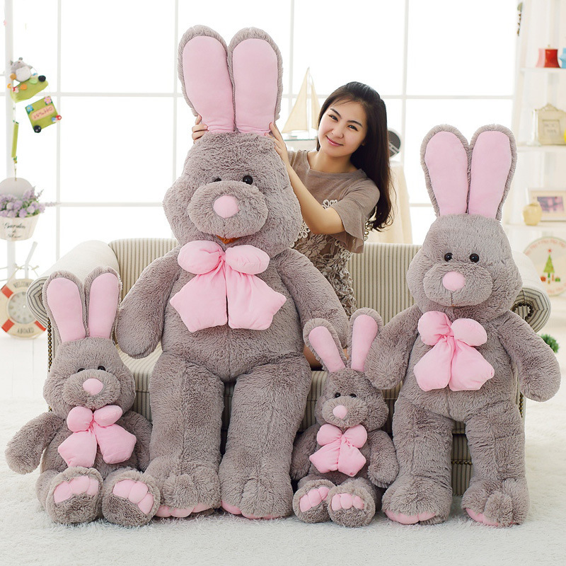 Rabbit plush toy in multiple sizes with soft gray fabric and pink bow, perfect for hugging, decorating sofas, and adding a cozy touch to home spaces