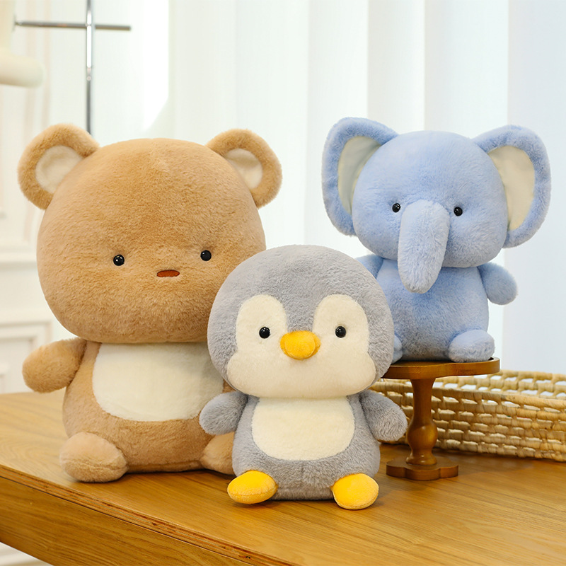 Bear, elephant and penguin plush toys displayed on wooden table, soft and cuddly animal plush toys for cozy home decor and relaxation