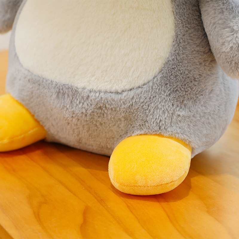 Penguin plush toy foot detail with soft plush fabric and smooth texture, showing fine stitching and a cozy, huggable design