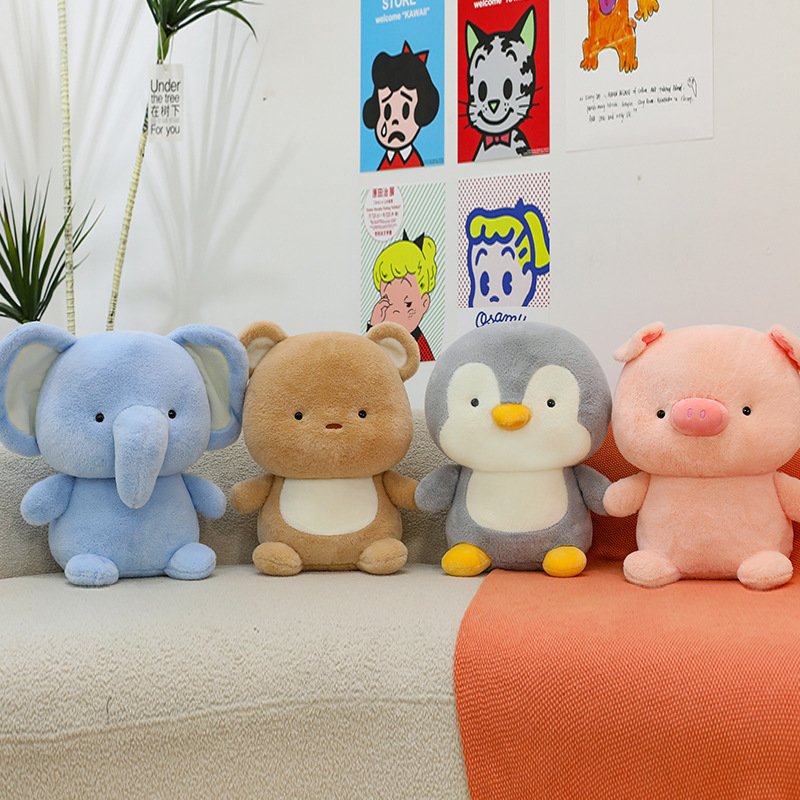 Animal plush toys including elephant, bear, penguin and pig, soft and cuddly stuffed animals displayed on a sofa in a cozy home setting