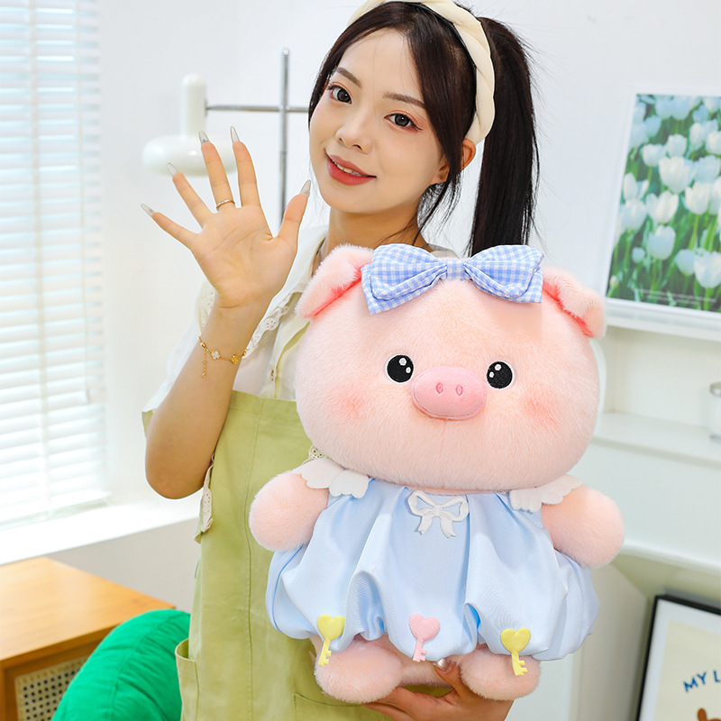 Bubble pig plush toy in blue dress with bow detail shown up close, soft plush material and cute rounded design, suitable for display and gifting