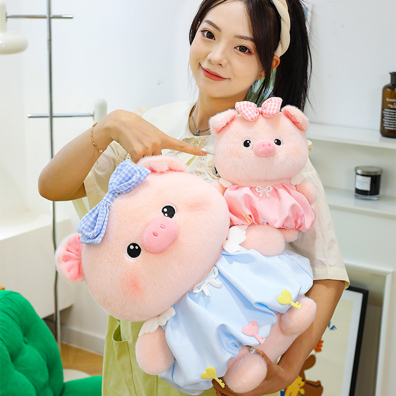 Bubble pig plush toys in blue and pink with bow dresses in different sizes, soft plush fabric and rounded shapes, perfect for cuddling and home decor styling