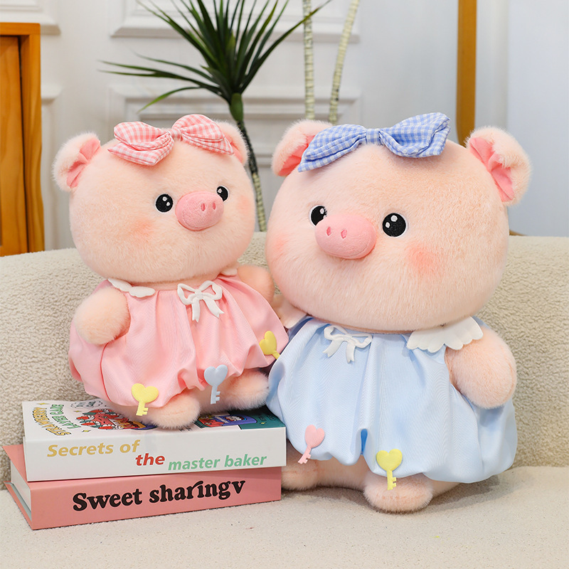Bubble pig plush toy in pink and blue with bow dress placed on books, soft plush fabric and cute design, perfect for shelf decor, display, and cozy room styling