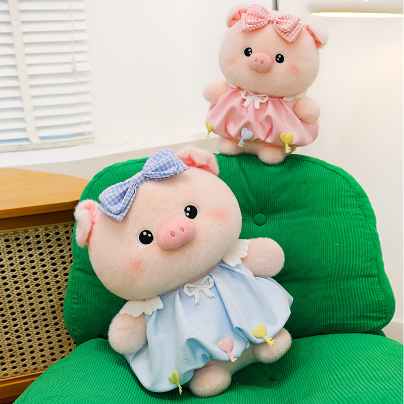 Bubble pig plush toys in blue and pink with bow dresses placed on green chair, soft plush texture and rounded design, ideal for home decor and cozy display