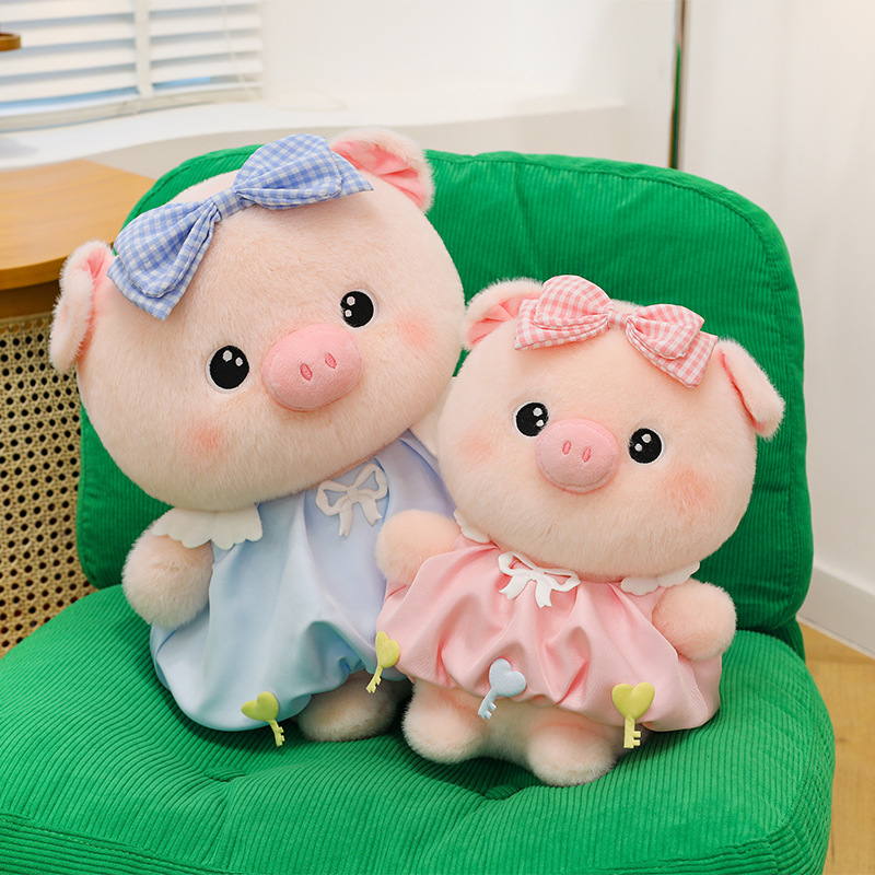 Bubble pig plush toy pair in pink and blue sitting on chair, featuring bow details and soft plush fabric, perfect for cuddling and adding a cute touch to home decor
