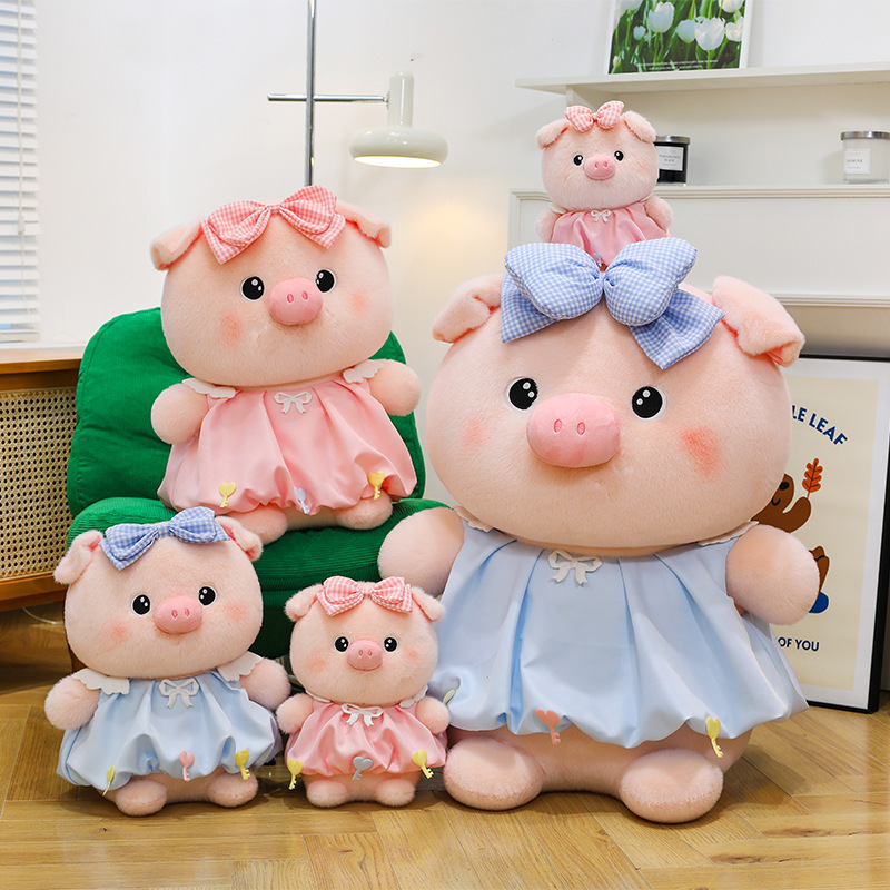 Bubble pig plush toys in pink and blue with bow dresses shown in multiple sizes on chair and floor, soft plush fabric and rounded design, ideal for cuddling, gifting and home decor