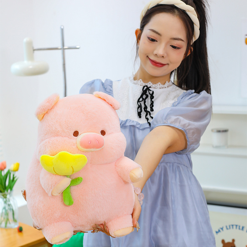 Pig plush toy with yellow flower design soft stuffed animal pillow held for display highlighting soft plush texture