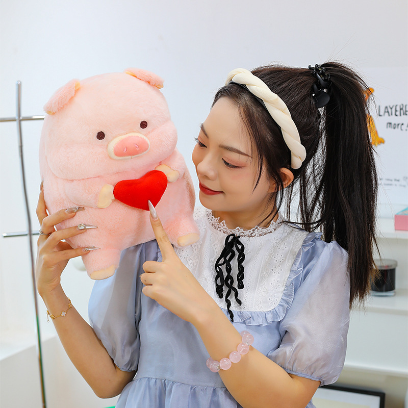 Pig plush toy with red heart detail soft stuffed animal pillow showing texture and design up close