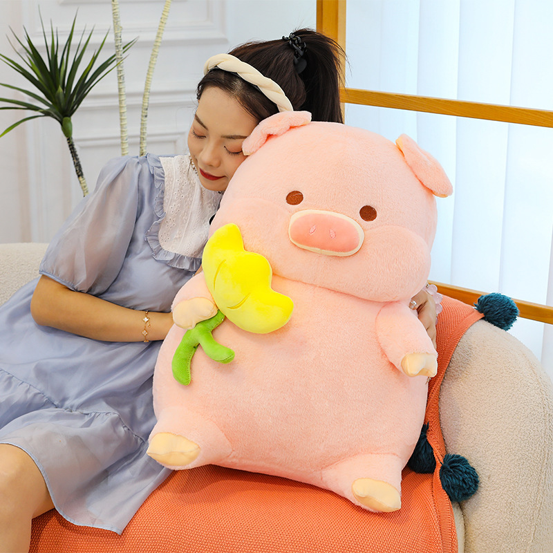 Pig plush toy pillow with flower design used for hugging and relaxing on sofa in a cozy home setting