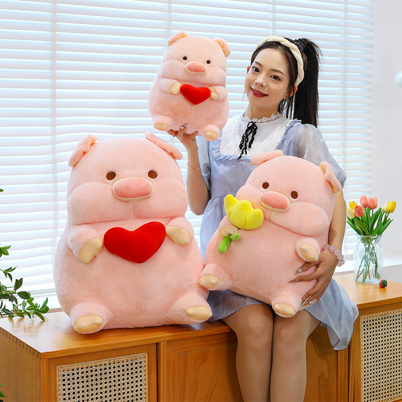 Cute pig plush toy in multiple sizes with heart and flower designs, soft stuffed animal pillows displayed on sofa for home decor and gifting