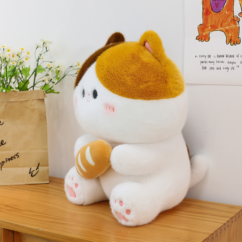 Side view of baguette cat plush toy sitting on wooden surface showcasing soft plush texture rounded shape and cozy home decor setting