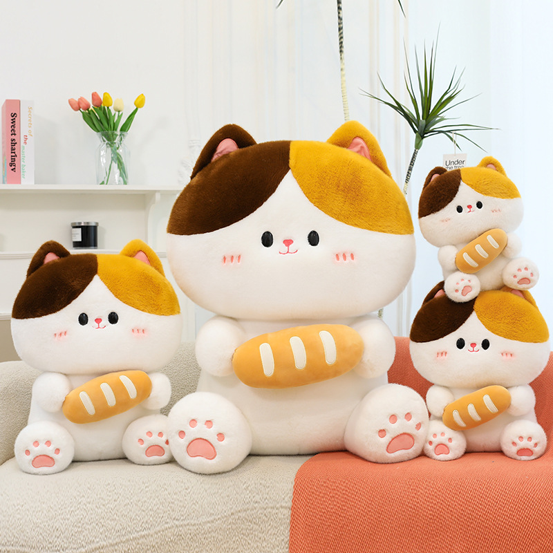 Baguette cat plush toy in different sizes placed on sofa featuring soft plush material and bread design in cozy home setting