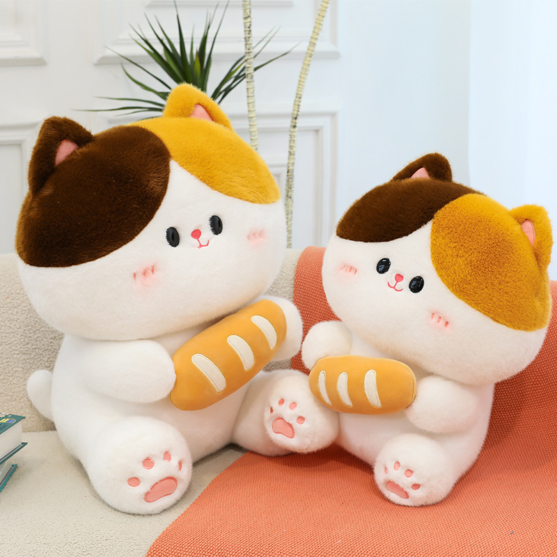 Baguette cat plush toys in different sizes placed on sofa showcasing soft plush texture cute facial details and cozy home setting