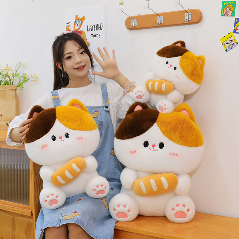 Baguette cat plush toy in multiple sizes arranged together showing soft plush texture rounded shape and bread design in cozy indoor setting